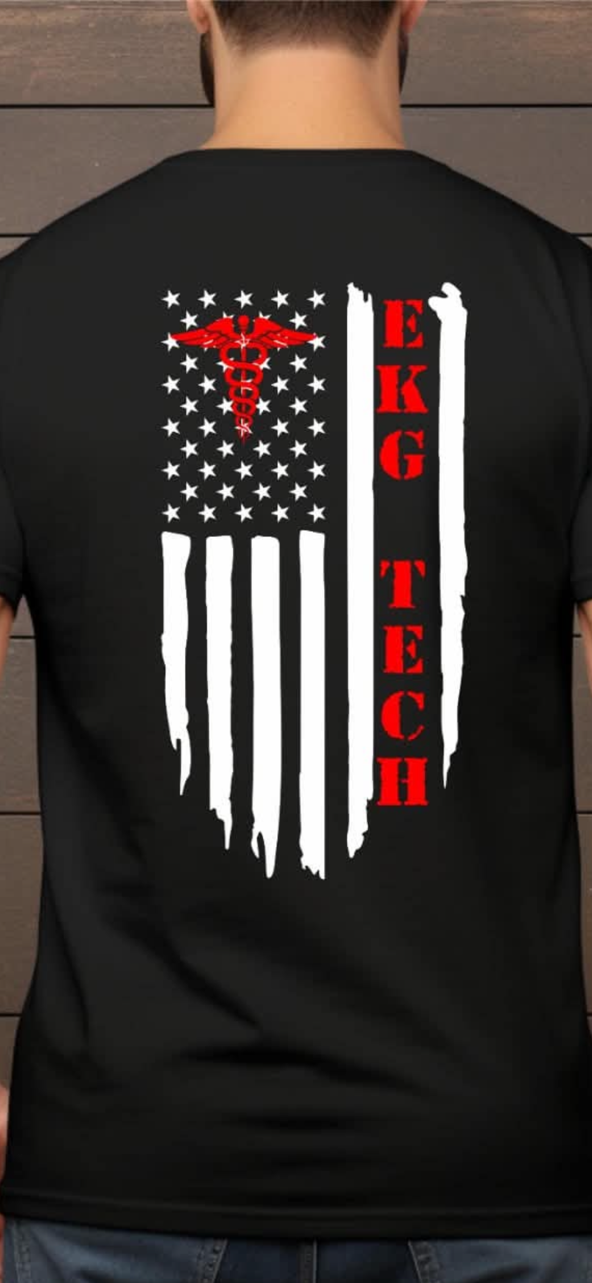 A man viewed from behind wearing a black t-shirt with a distressed American flag graphic on the back. The flag features white stars, white vertical stripes, a red caduceus symbol, and the text 'EKG TECH' in red.